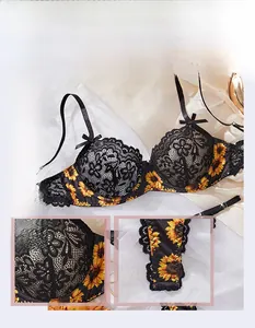 Close-up detail of sunflower embroidery and black floral lace on a sexy bra set