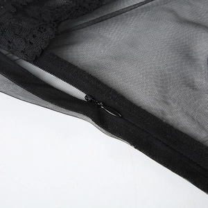 Detailansicht der schwarzen Spitzbordüre und des verdeckten Reißverschlusses am Netzkleid