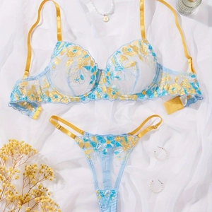 Detailed flat lay of blue lace lingerie set with yellow floral embroidery and pearls