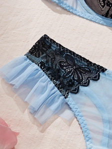Détail de maille bleu clair et dentelle florale noire sur cet ensemble lingerie