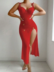 Détail d'une robe lingerie en maille rouge avec broderies papillon dorées et fente haute