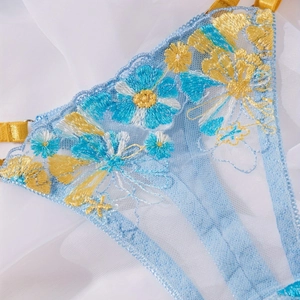 Close-up of yellow and blue floral embroidery on sheer mesh fabric of lingerie set