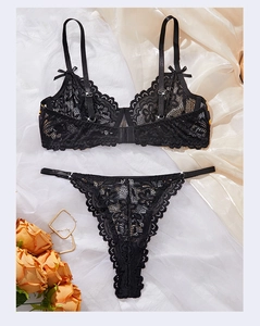 Detailed flat lay of black sunflower lace lingerie set with bow accents on silk fabric