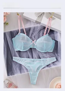 Detailed flat lay of blue lace lingerie set with pink straps and mesh splicing textures