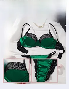 Close-up of dark green satin bra set with delicate black eyelash lace and metal rings