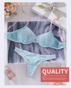 Flat lay of light blue mesh lingerie set with pink straps and decorative gift box
