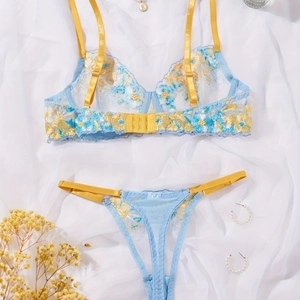 Lace bra set with blue lace and yellow floral embroidery on white silk background