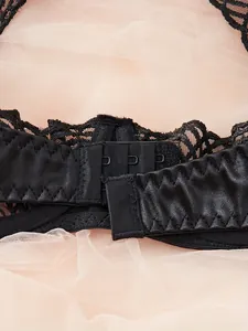 Detailed close-up of three-row hook-and-eye back closure on black lace lingerie