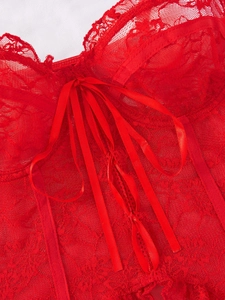 Macro detail of red floral lace bra with satin ribbon lacing and underwire support