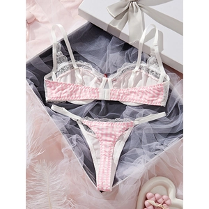 Pink and white checkered lace lingerie set with bra and thong on a romantic gift background
