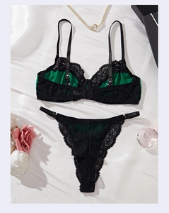 Detail of black lace lingerie set with emerald green satin lining and floral accents