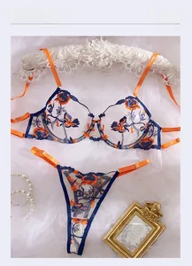 Detail of floral embroidery on navy mesh bra with orange contrast straps and underwire
