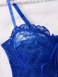Close-up of royal blue lace bra detailing with intricate floral patterns and thin straps