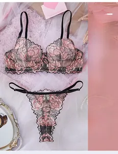 Flat lay of pink floral embroidery lingerie set with black trim on mesh fabric