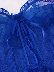 Detail of royal blue floral lace corset with criss-cross satin ribbon ties and scalloped edges