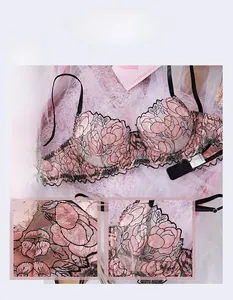 Detail of pink floral embroidery on sheer mesh lingerie with elegant black trim accents