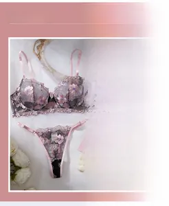 Close-up of pink floral embroidery and precise stitching on grey lace lingerie set