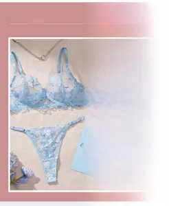 Close-up of light blue floral embroidery on sheer lace lingerie set with fine stitching