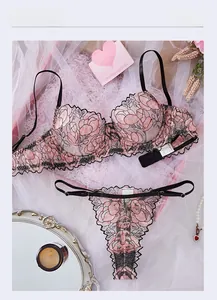 Exquisite flat lay of black floral embroidery lingerie set with decorative accessories