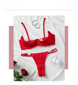 Detailed flat lay of a red satin lingerie set featuring silver metal chain straps