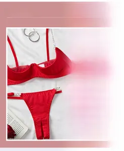 Detailed close-up of red satin lingerie set featuring silver metal chains and lace-up design