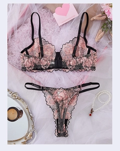 Close-up of pink lace lingerie set with black rose floral embroidery and adjustable straps