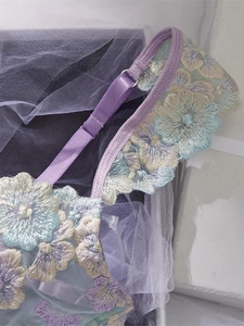 Detail of floral embroidery on light purple mesh lingerie with adjustable strap