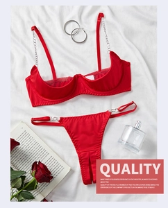 Flat lay of red silk lingerie set featuring steel underwire and elegant metal chain straps