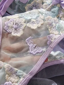 Detail of floral embroidery on purple mesh lace with delicate satin trim lingerie