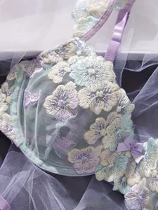 Detail of floral embroidery on sheer mesh lingerie with a lavender bow accent