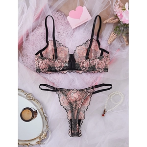 Lace lingerie set with pink floral embroidery and black trim in a gift box setting