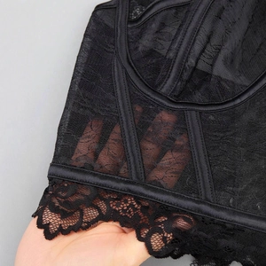 Detail of sheer black lace embroidery and fishbone support on this plus size corset