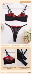 Dettaglio ricamo floreale rosso su set reggiseno e perizoma in rete nera trasparente