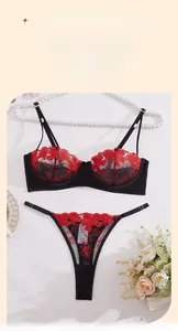Dettaglio del ricamo floreale rosso su set di lingerie in mesh nero e pizzo elegante
