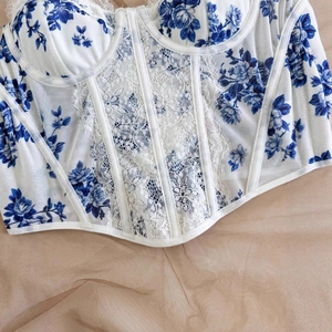 Detail of blue and white floral corset with lace panels and boning structure