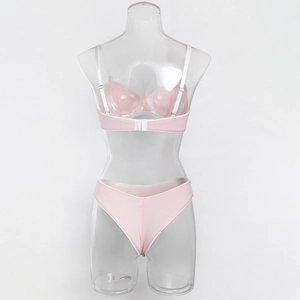 Detail view of pink ribbed lingerie set with white trim and adjustable straps on model