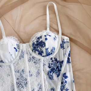 Detailed macro view of white floral corset top with delicate lace and steel ring support