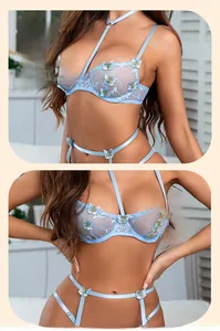 Détail d'un ensemble de lingerie en dentelle bleu clair avec broderie papillon et maille