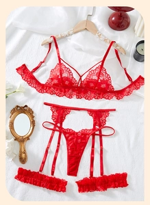 Flat lay detail of red lace lingerie set with floral embroidery and garter belt detail