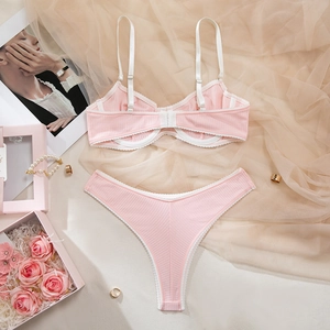 Pink ribbed lingerie set with white trim, wireless bra and V-cut panty on elegant display