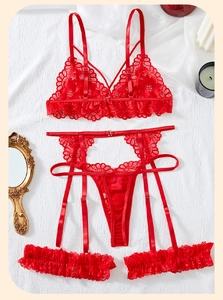Flat lay of red floral lace lingerie set with suspenders on elegant textured background