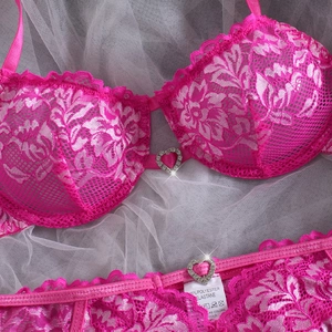 Rose pink lace bra and panty set with heart rhinestone charms on white tulle backdrop