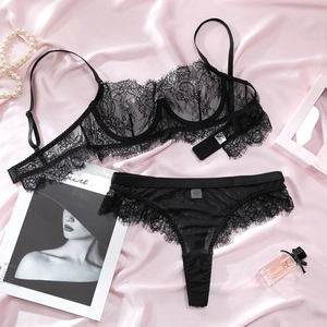 Detailed view of black eyelash lace lingerie set with underwire bra on pink silk