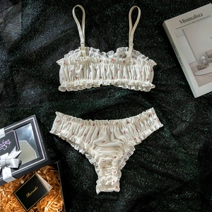 Détail d'un ensemble de lingerie à imprimé cerise crème avec bords à volants et texture côtelée