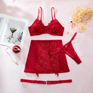 Flachbild-Detail eines roten vierteiligen Spitzen-Dessous-Sets mit floralem Netzgewebe