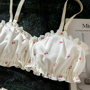 Détail du soutien-gorge blanc à imprimé cerise avec bords à volants et fines bretelles