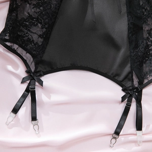 Détail de la dentelle florale noire et du satin avec jarretelles et petits noeuds