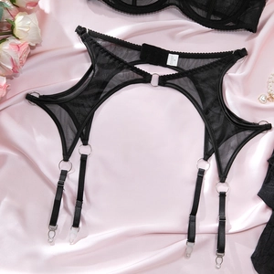 Detail of black mesh garter belt with silver metal rings on pink silk background