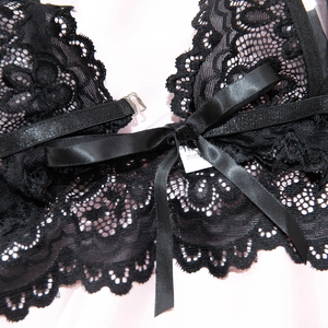 Detail of floral lace bodysuit featuring front buckle closure and satin bow decoration