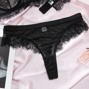 Detailed view of sexy black eyelash lace panties on a soft pink silk background